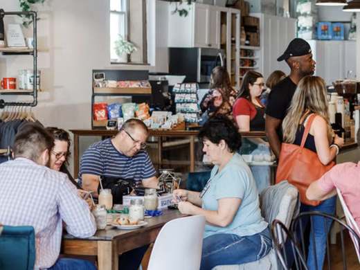 A busy morning inside Zeb's Coffeehouse, with friends playing cards at a table and customers lined up at the counter